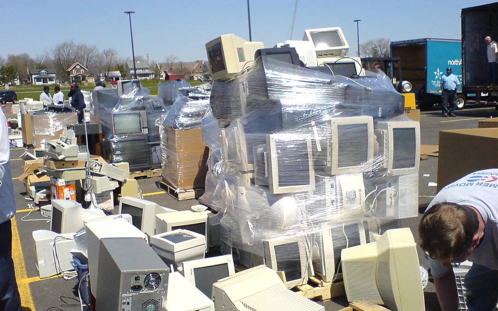 Old computers and electronics stacked on pallets at an electronics recycling collection event